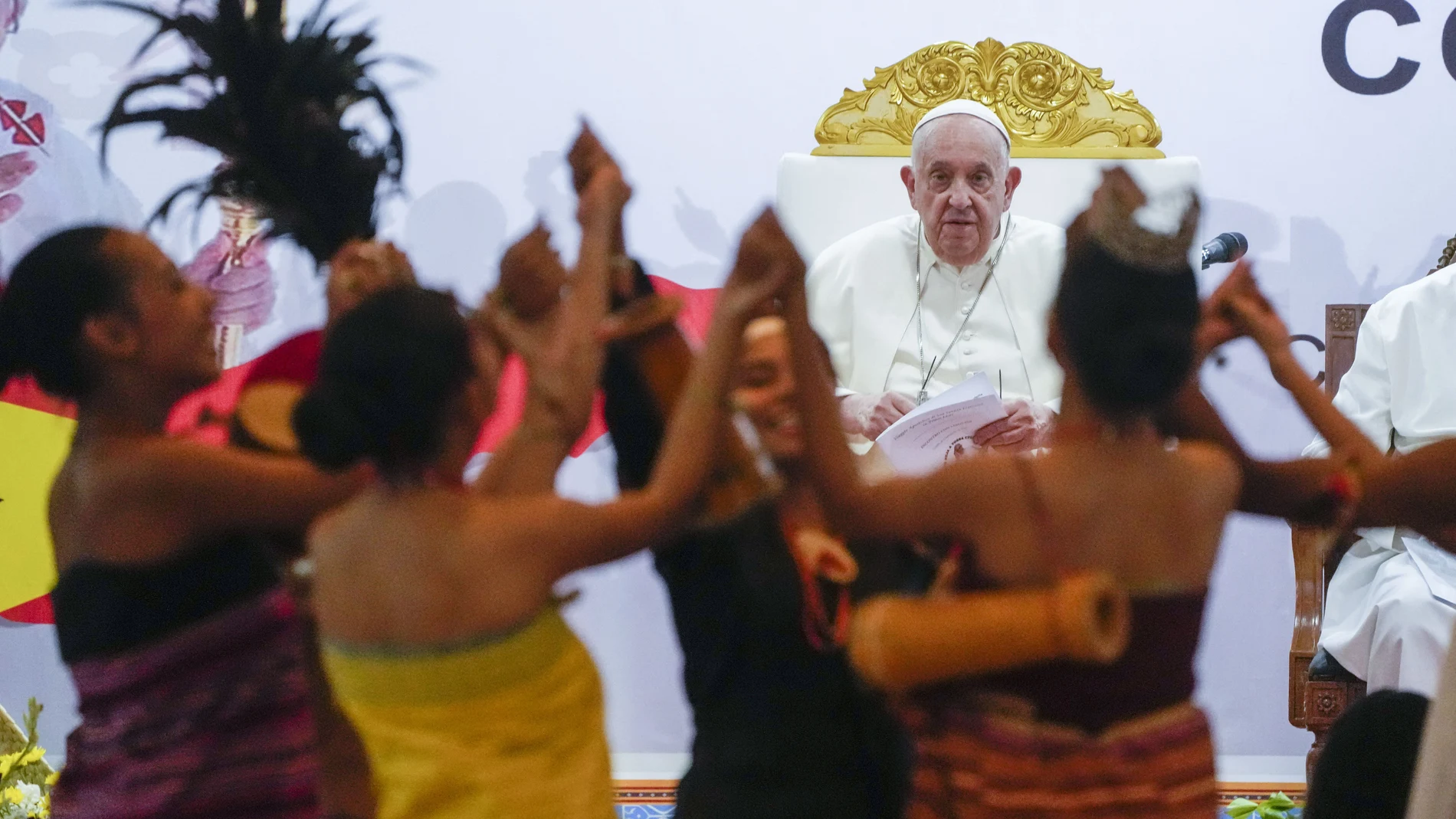Pope Francis looks at traditional dancers as he arrives at the Centro de Convenções in Díli, East Timor