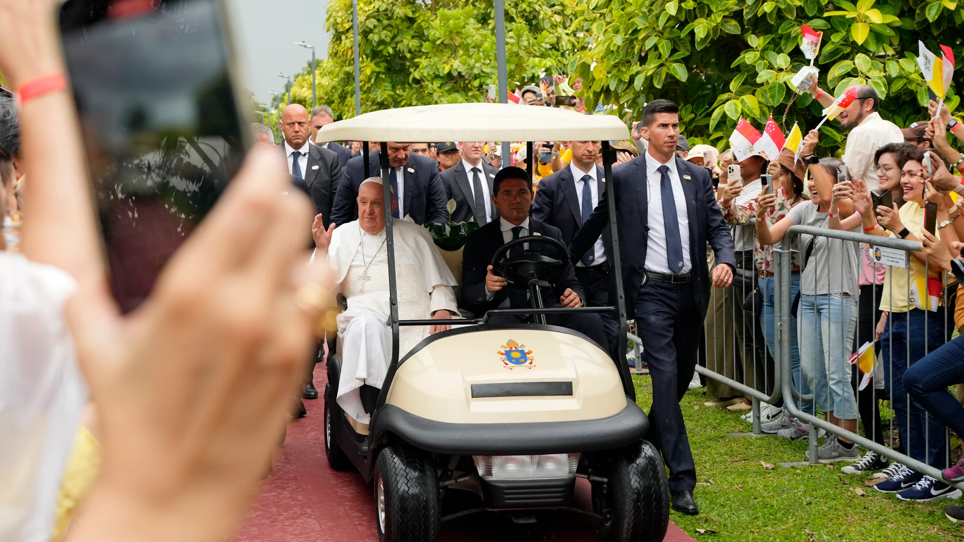 Pope Francis travels in a buggy as he greets the volunteers on his arrival in Singapore, Wednesday, Sept. 11, 2024. (AP Photo/Vincent Thian)