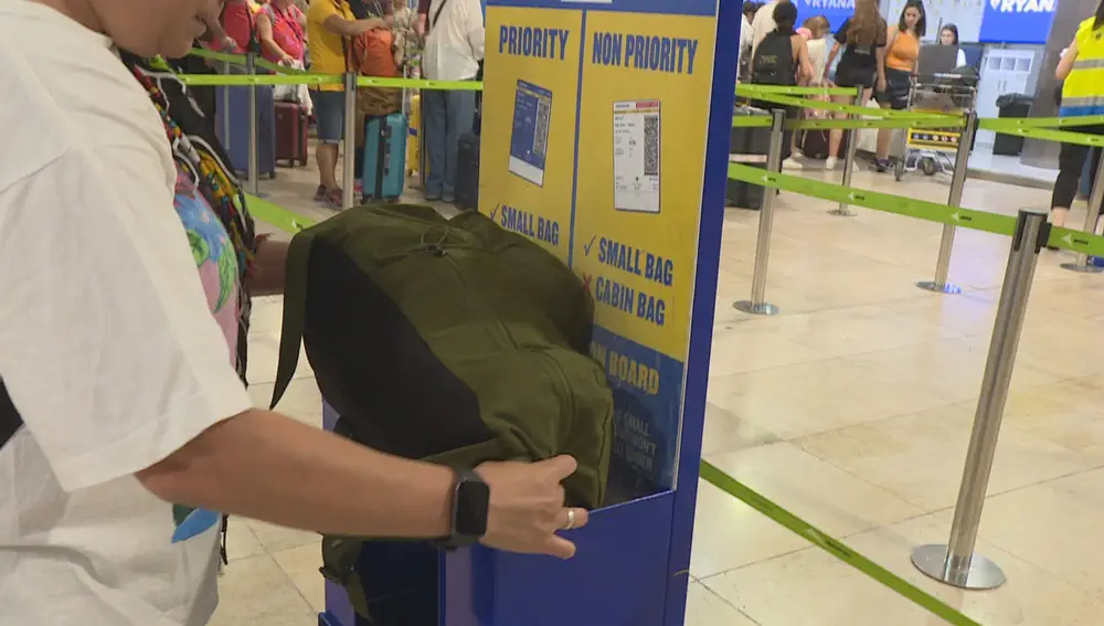 Viajero midiendo el tamaño de su equipaje en el aeropuerto