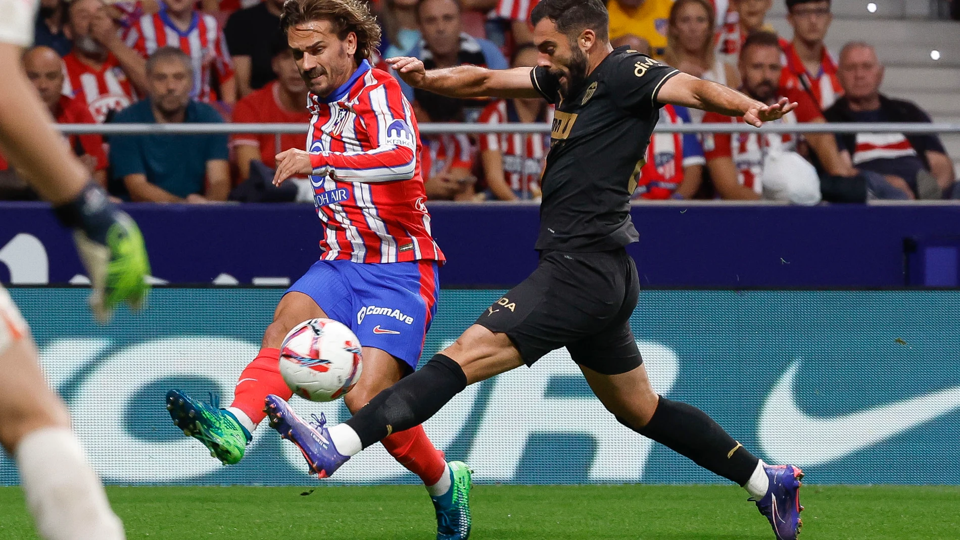 MADRID, 15/09/2024.- El delantero francés del Atlético de Madrid Antoine Griezmann (i) centra el balón ante Luis Rioja, del Valencia CF, durante el partido de la quinta jornada de LaLiga EA Sports entre el Atlético de Madrid y el Valencia CF, este domingo en el Cívitas Metropolitano de la capital española. EFE/JJ Guillén