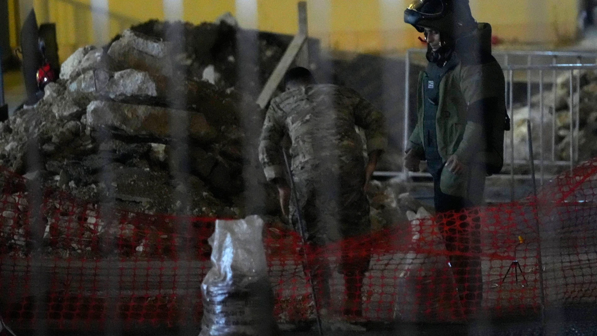 A Lebanese army bomb disposal specialist wearing a protective gear prepares, with his comrade, to detonate a walkie-talkie that was found at the parking of the American University Hospital, in Beirut, Lebanon, Wednesday, Sept. 18, 2024. (AP Photo/Hassan Ammar)