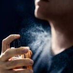Un hombre perfumándose 