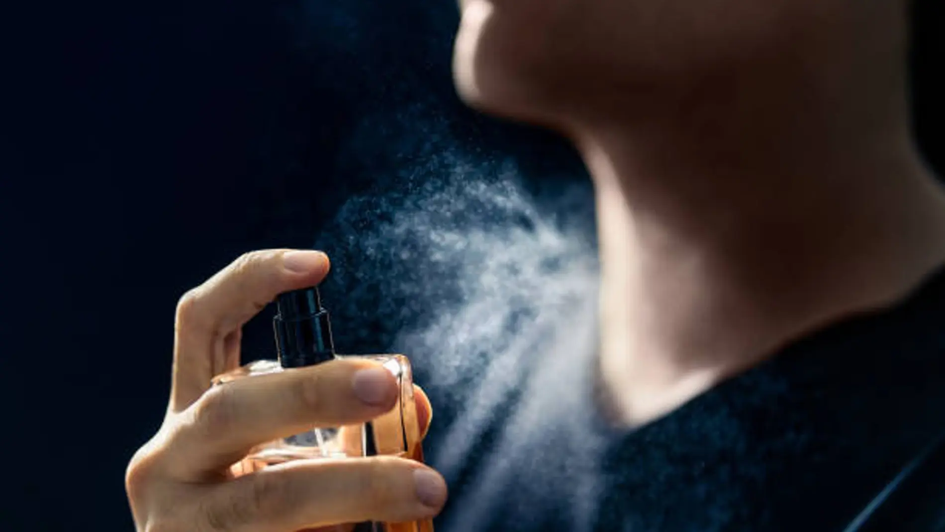 Un hombre perfumándose