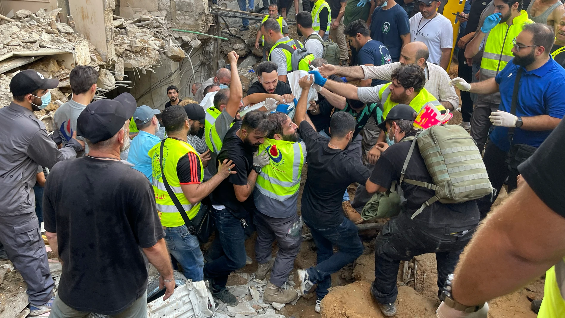 Rescuers carry a body at the scene of a missile strike in the southern suburbs of Beirut, Friday, Sept. 20, 2024. (AP Photo/Bilal Hussein)