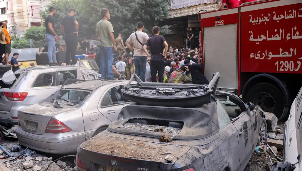 People and first responders gather in front of a building targeted by an Israeli strike in Beirut's southern suburbs on September 20, 2024. - The strike on Hezbollah's stronghold in Lebanon's capital Beirut reportedly killed at least eight people and wounded dozens of others, with a source close to the movement saying a top military leader was dead.