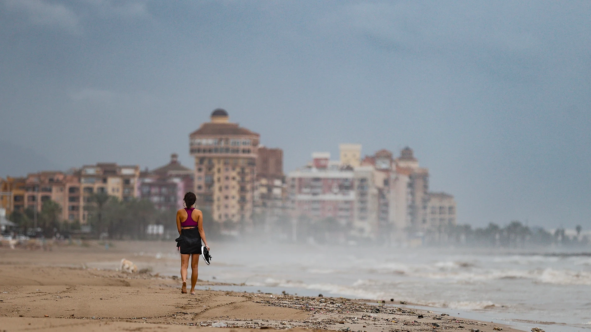 FOTODELDÍA GRAFCVA3068. ALBORAYA (VALENCIA), 21/09/2024.- Una mujer pasea este sábado por la playa de La Patcona en Alboraya (Valencia). La Agencia Estatal de Meteorología (Aemet) ha activado para este sábado el aviso naranja por lluvias en la provincias de Castellón y Valencia, donde pueden acumularse precipitaciones de entre 40 y 50 litros por metro cuadrado en una hora y de 150 l/m2 en 12 horas. EFE/Manuel Bruque