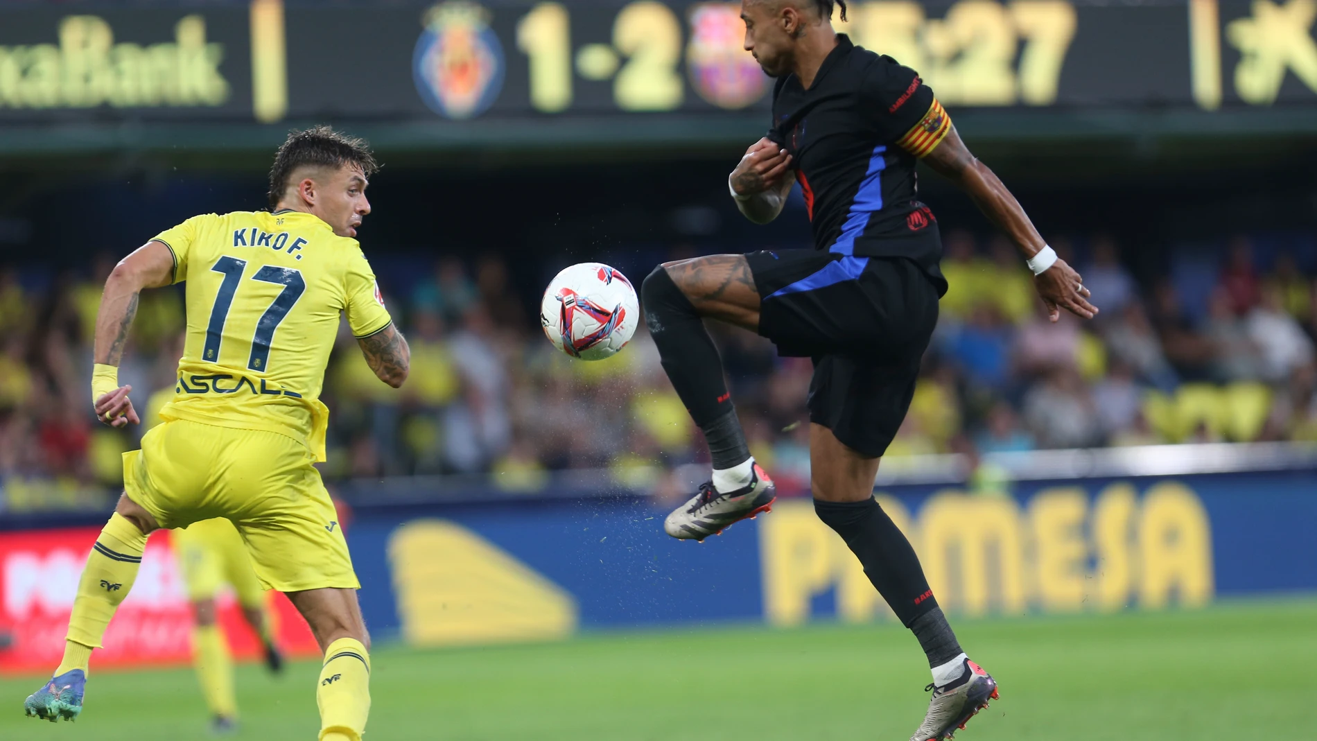 Barcelona's Raphinha, right, and Villarreal's Kiko Femenia battle for the ball during a Spanish La Liga soccer match at the La Cerámica stadium in Villarreal, Spain, Sunday, Sept. 22, 2024. (AP Photo/Alberto Saiz)