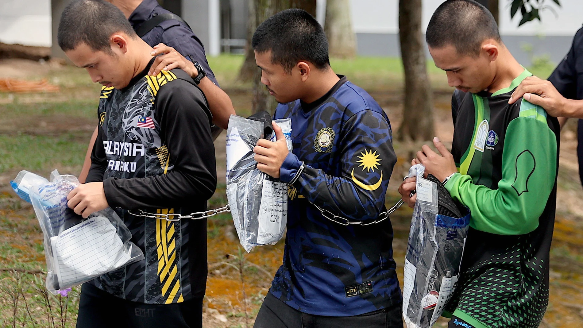 Tres de los detenidos en Malasia son custodiados por agentes de policía