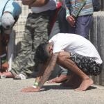 Un inmigrante se apoya en el suelo tras ser rescatado en la costa de Cádiz