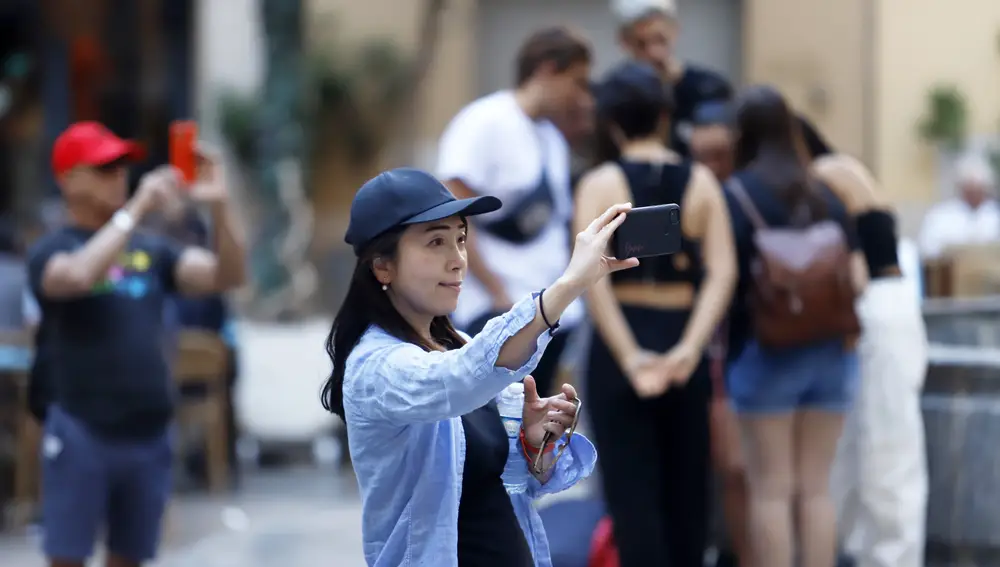 Una turista se fotografía en una calle de la capital malagueña
