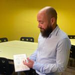 El coordinador del equipo de protección a la infancia de Maristes Catalunya, Raúl García, muestra una agenda con un código QR con un acceso directo al canal de denuncia