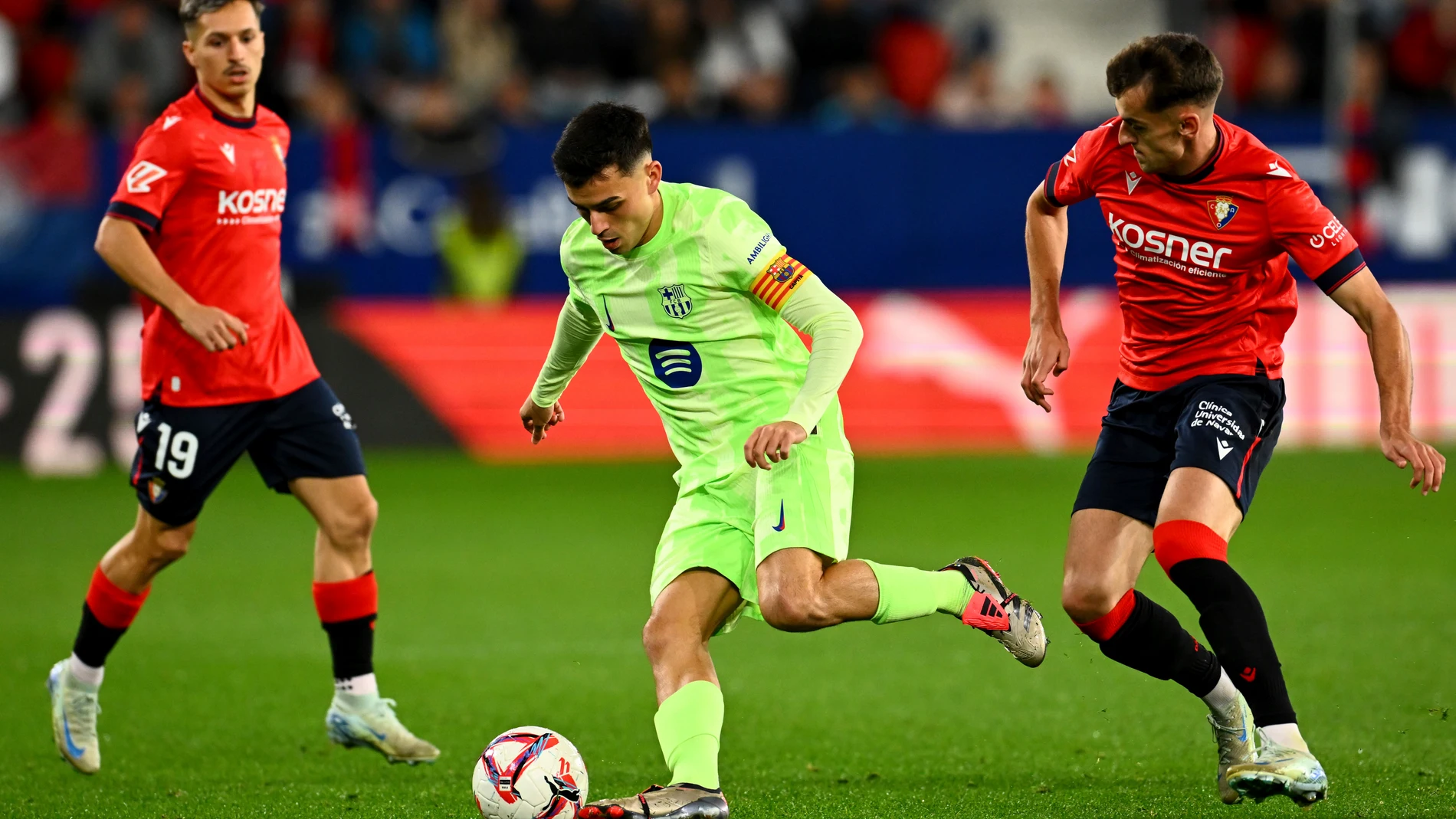 Barcelona's Pedri fights for the ball against Osasuna's Bryan Zaragoza during a Spanish La Liga soccer match between Osasuna and Barcelona at El Sadar stadium in Pamplona, Spain, Saturday, Sept. 28, 2024. (AP Photo/Miguel Oses)