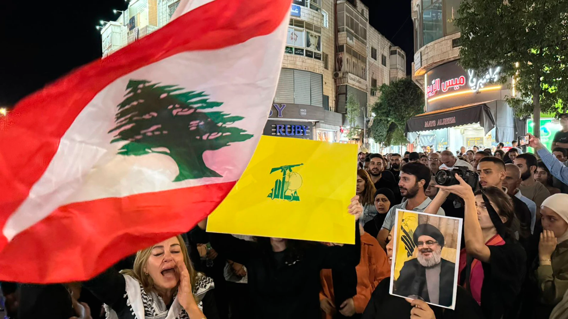 Palestinian protesters carry Lebanese flags, Hezbollah flags and posters with a picture of Hezbollah leader Sayyed Hassan Nasrallah during a rally in support of Hezbollah, in the West Bank city of Ramallah Saturday, Sept. 28, 2024. (AP Photo/Nasser Nasser)