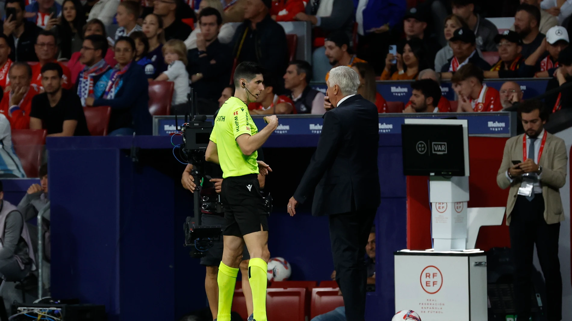 MADRID, 29/09/2024.- El entrenador del Real Madrid, Carlo Ancelotti (d), conversa con el colegiado Busquets Ferrer (i), durante el encuentro correspondiente a la jornada 8 de LaLiga EA Sports disputado entre el Atlético de Madrid y el Real Madrid en el estadio Civitas Metropolitano de Madrid. EFE/ J.J Guillén