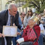 El alcalde de Segovia, José Mazarías, entrega un distintivo a una de las "Isabeles"