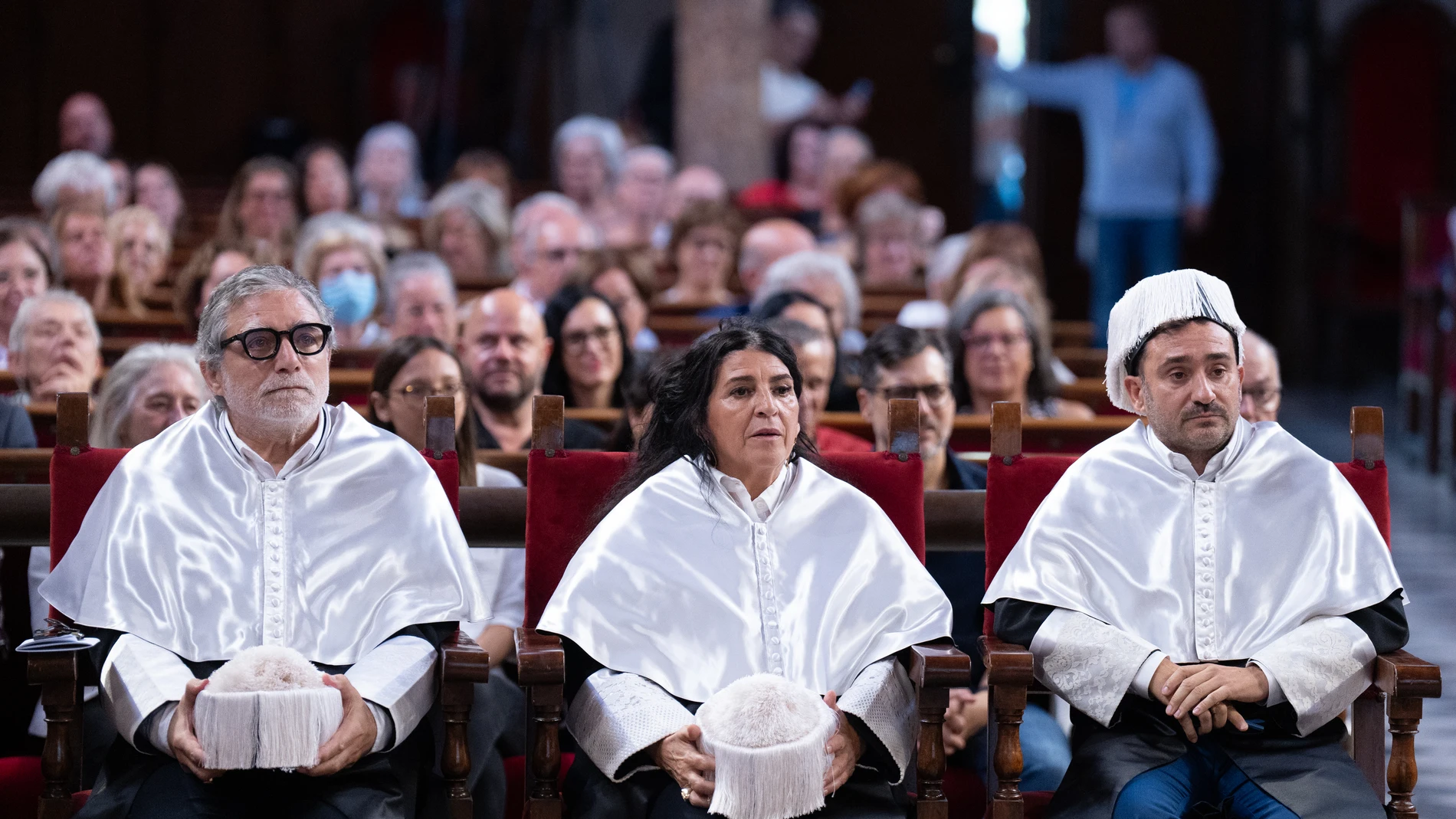 (I-D) El escultor Jaume Plensa; la pintora Lita Cabellut y el cineasta Juan Antonio Bayona, durante el acto en el que han sido investidos doctores Honoris causa, en la Universitat de Barcelona (UB), a 30 de septiembre de 2024, en Barcelona, Catalunya (España). La Universidad de Barcelona (UB) ha concedido la distinción de doctorado Honoris causa a estas figuras del mundo de la cultura por sus aportaciones a las diferentes disciplinas que representan. 30 SEPTIEMBRE 2024;BARCELONA;DOCTORES HON...