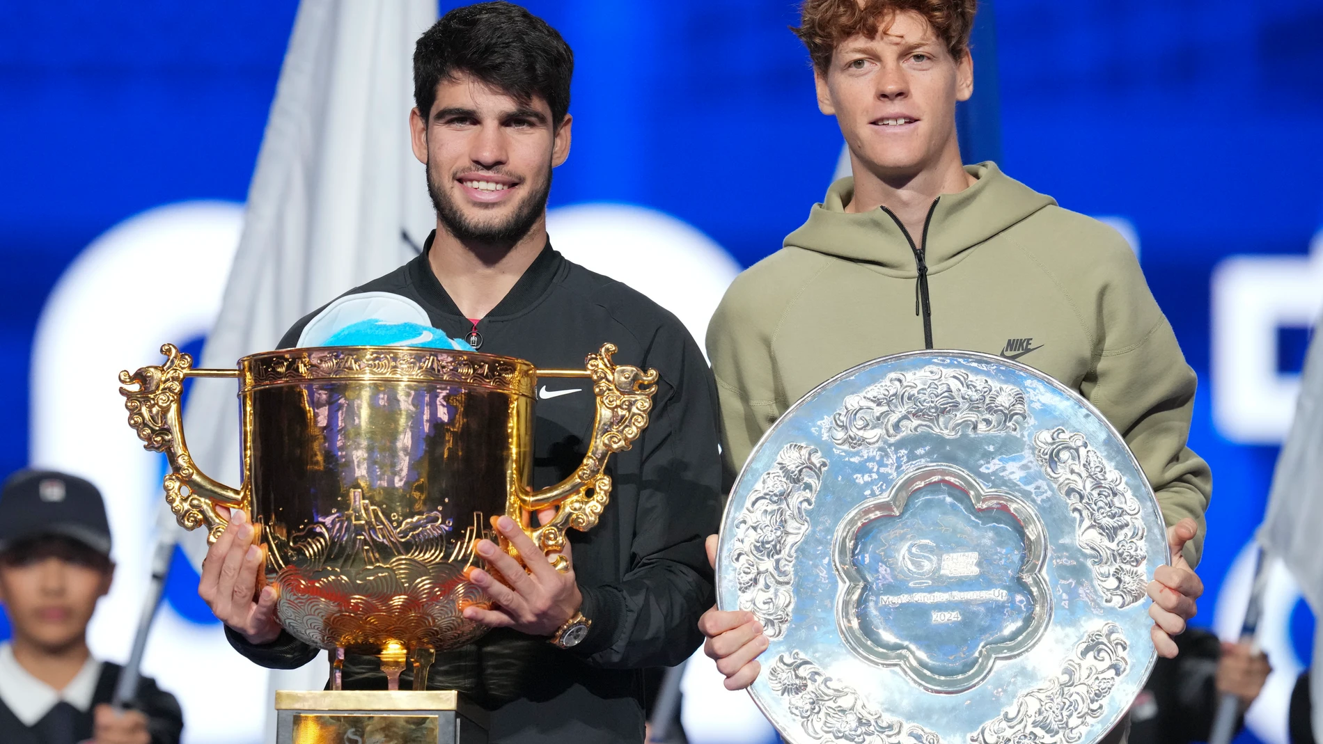 Carlos Alcaraz, left, of Spain poses with his trophy after winning against Jannik Sinner, right, of Italy during their men's singles finals match of the China Open tennis tournament, at the National Tennis Center in Beijing, Wednesday, Oct. 2, 2024. (AP Photo/Achmad Ibrahim)