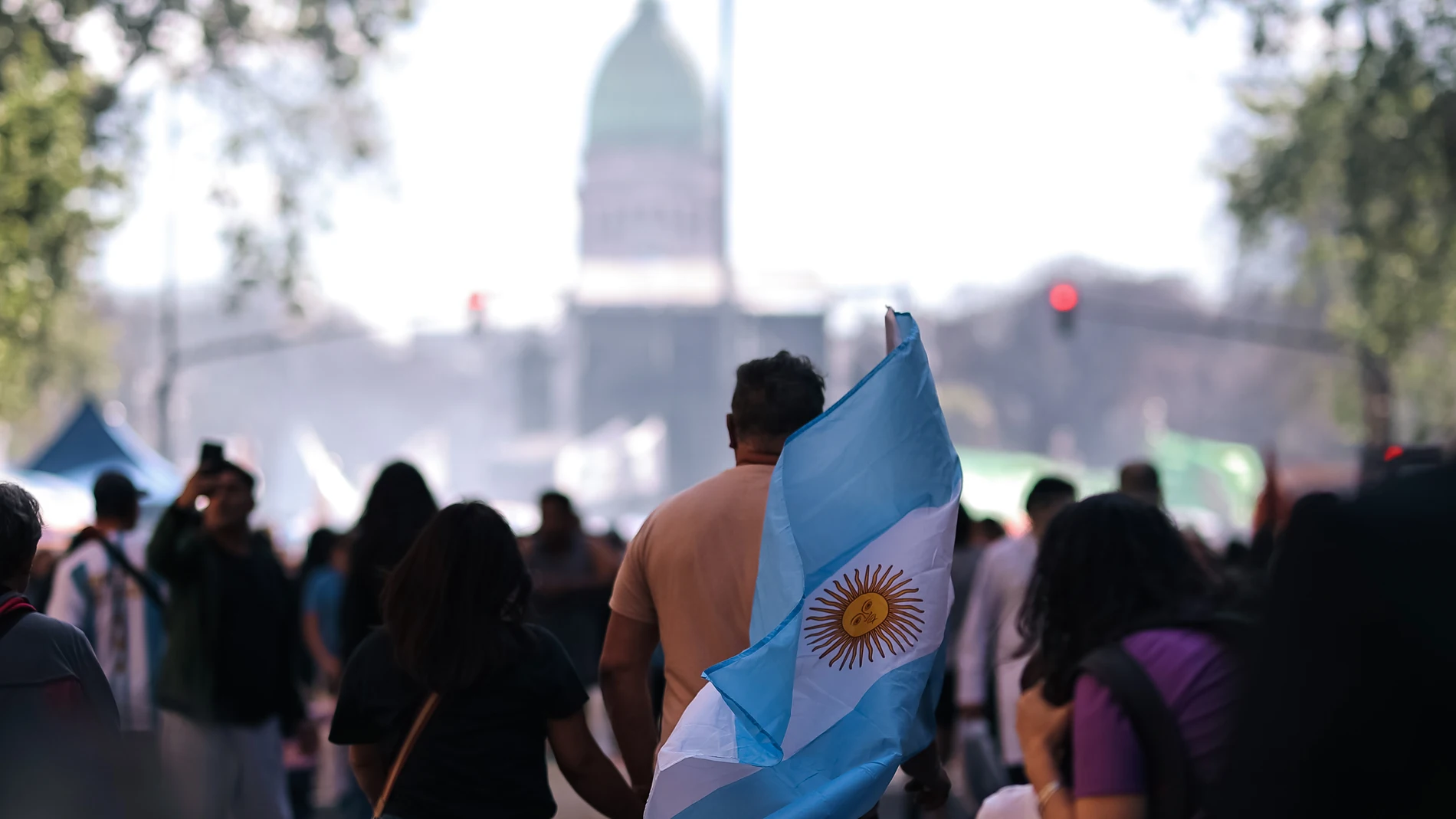 AME4304. BUENOS AIRES (ARGENTINA), 03/10/2024.- Un manifestante sostiene una bandera de Argentina en una marcha este miércoles, en Buenos Aires (Argentina). Profesores y alumnos de universidades públicas de Argentina, con el respaldo de otros sectores, se vuelcan a las calles para protestar contra la intención del presidente del país, Javier Milei, de vetar una ley recientemente aprobada que garantiza mayor financiación a la educación universitaria. EFE/ Juan Ignacio Roncoroni