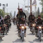 Armed Taliban security personnel ride motorcycles along a road in Khost on September 30, 2024. 