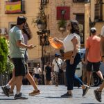 Varios viandantes en el centro de Toledo bajo las altas temperaturas