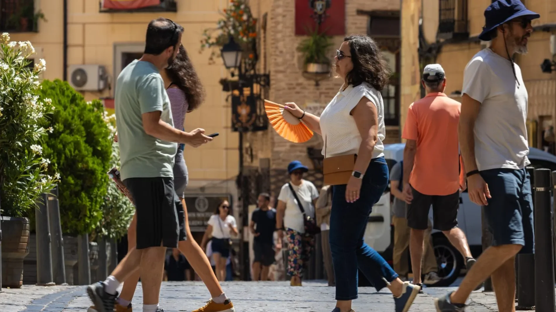 Varios viandantes en el centro de Toledo bajo las altas temperaturas