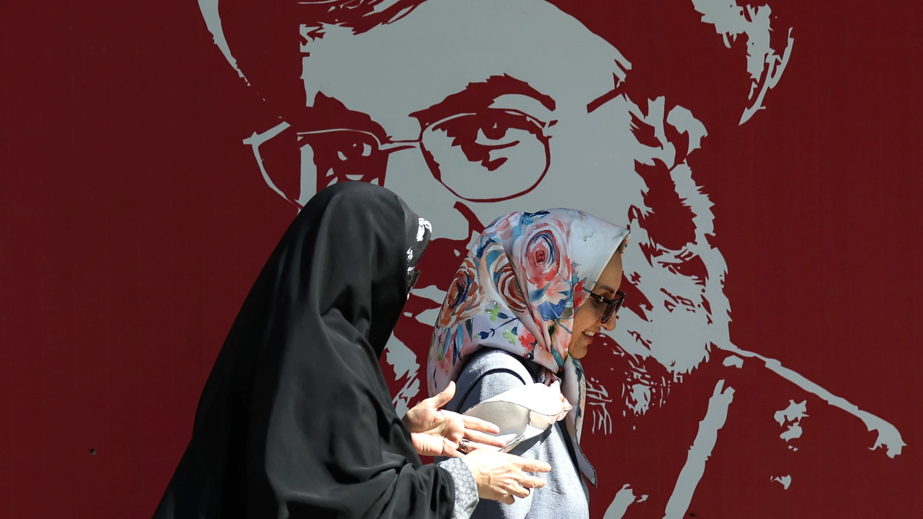 Tehran (Iran(islamic Republic Of)), 07/10/2024.- Iranian women walk past a portrait of late Hezbollah leader Hassan Nasrallah displayed in a street in Tehran, Iran, 07 October 2024. Tensions are growing between Iran and Israel following Iran's large-scale missile attack on Israel. Iran fired more than 180 ballistic missiles directed at Israel late on 01 October 2024, in 'retaliation for different assassinations' carried out by Israel and 'the crimes in Palestine and Lebanon', Islamic Revoluti...