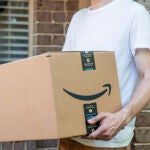 Un repartidor con una caja de Amazon