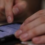 Persona revisando mensajes en un teléfono móvil