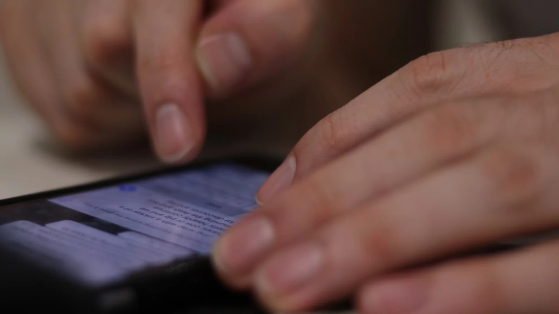 Persona revisando mensajes en un teléfono móvil