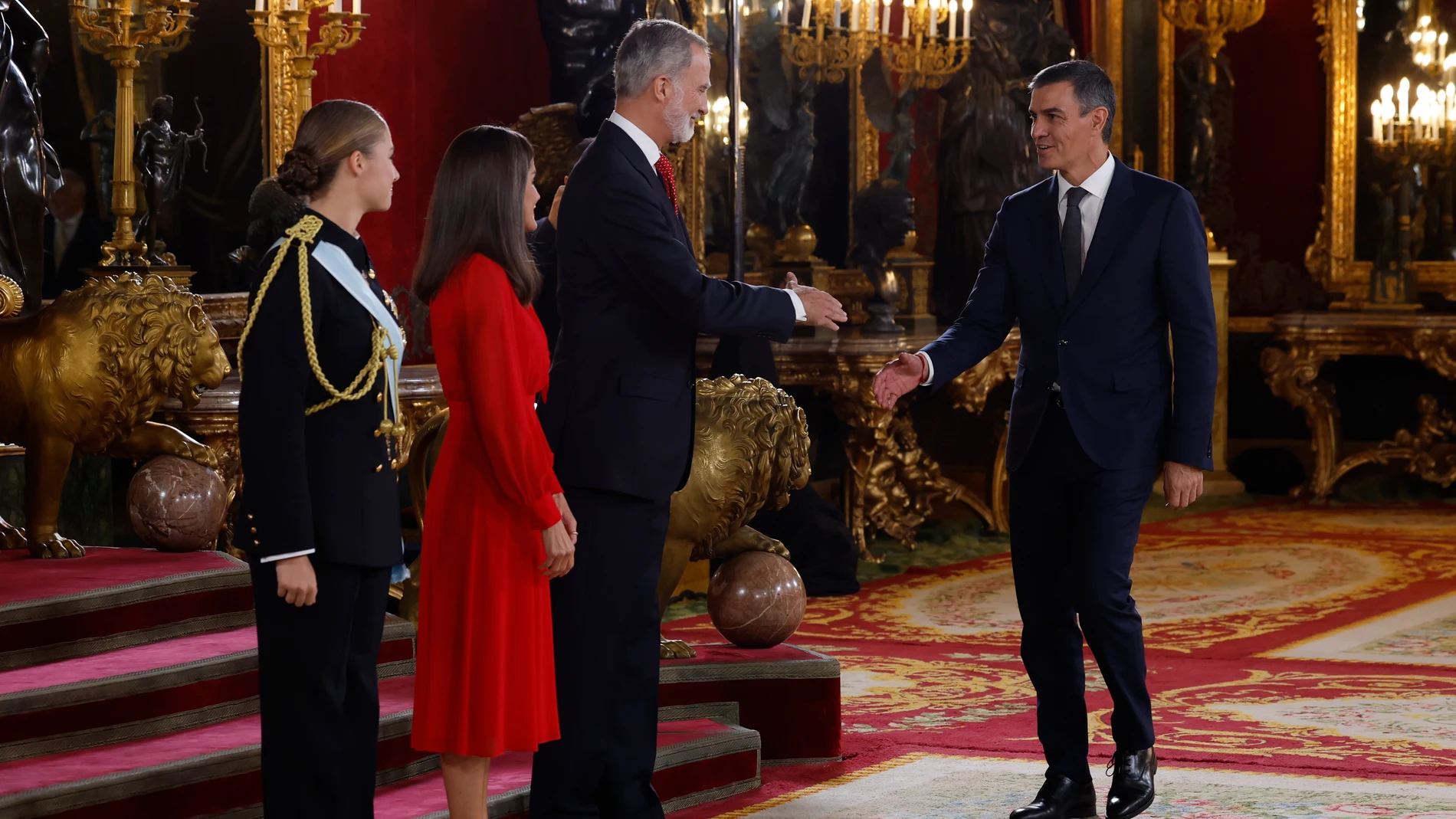 MADRID, 12/10/2024.- Los reyes Felipe y Letizia, acompañados por la princesa de Asturias, Leonor de Borbón, reciben al presidente del Gobierno, Pedro Sánchez (d), a su llegada a la recepción con motivo del día de la Fiesta Nacional de España, celebrada tras el tradicional desfile, este sábado en el Palacio Real de Madrid. EFE/J.J. Guillén
