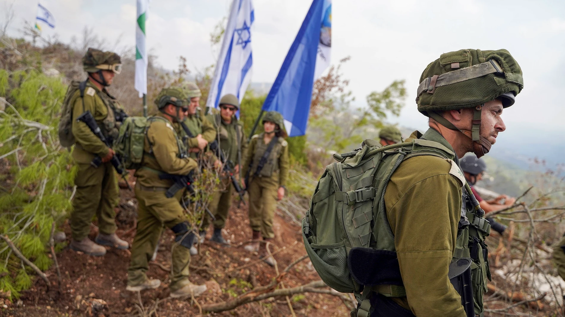 -FOTODELDÍA- LABOUNEH (LÍBANO), 13/10/2024.- Soldados de las Fuerzas de Defensa de Israel conversan junto banderas israelíes en territorio del sur de Líbano, zona controlada por el ejército israelí, en la que hasta hace muy poco operaba la milicia Hizbulá. EFE/Alejandro Ernesto
