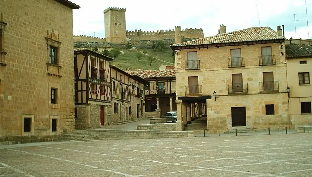 Calles del pueblo y al fondo el castillo de Peñaranda