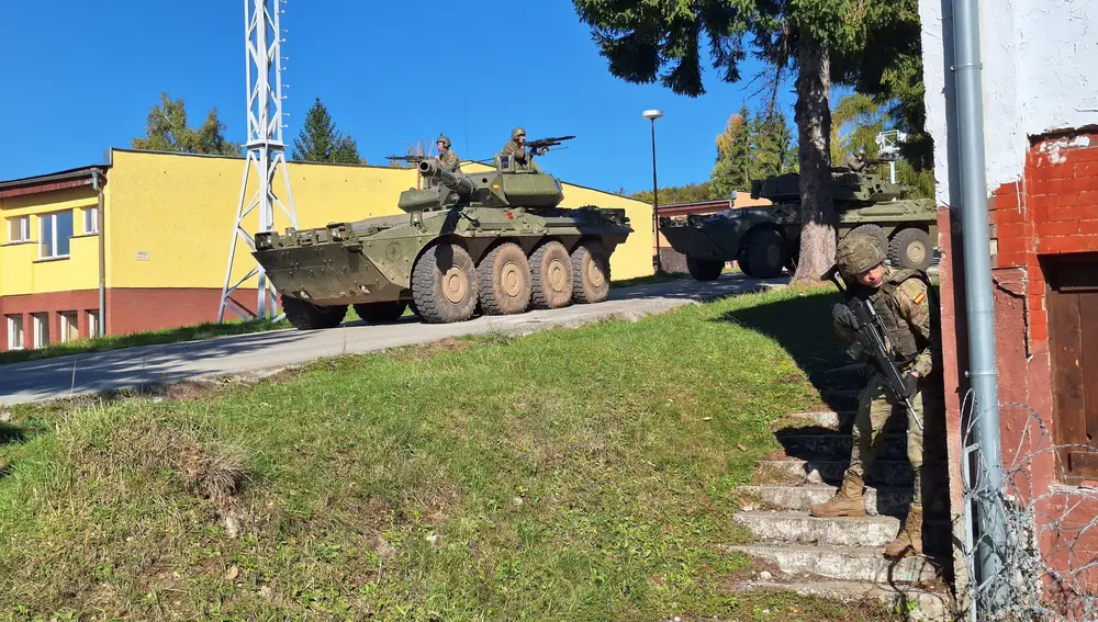 Dos vehículos «Centauro» españoles avanzan mientras un militar comprueba que no hay enemigos
