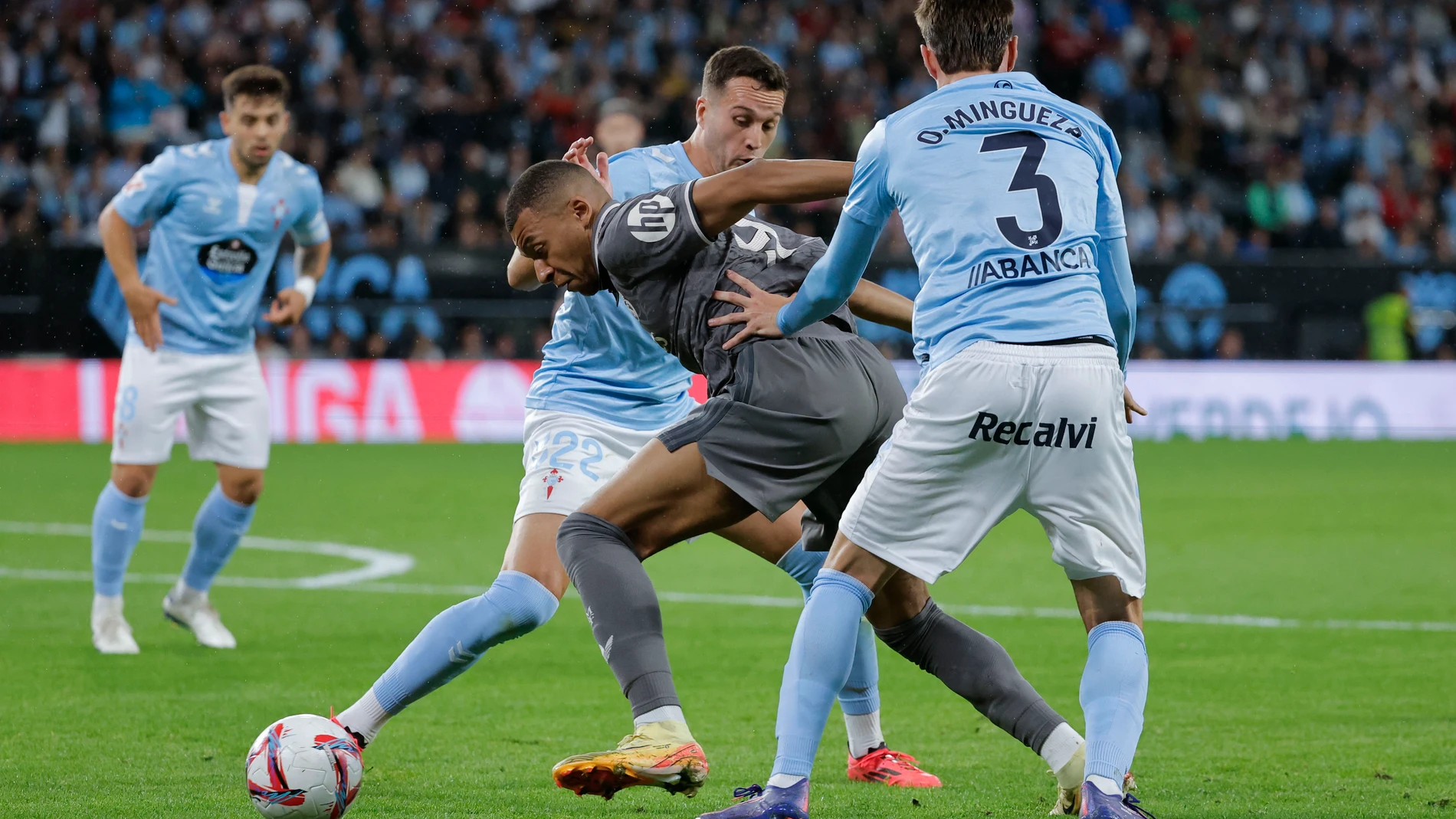 VIGO (PONEVEDRA), 19/10/2024.- El delantero del Real Madrid Kylian Mbappé (i) escapa entre Óscar Mingueza (d) y Javier Manquillo, ambos del Celta, durante el partido de la décima jornada de LaLiga EA Sports que Celta de Vigo y Real Madrid disputan este sábado en el estadio de Balaídos. EFE/Lavandeira