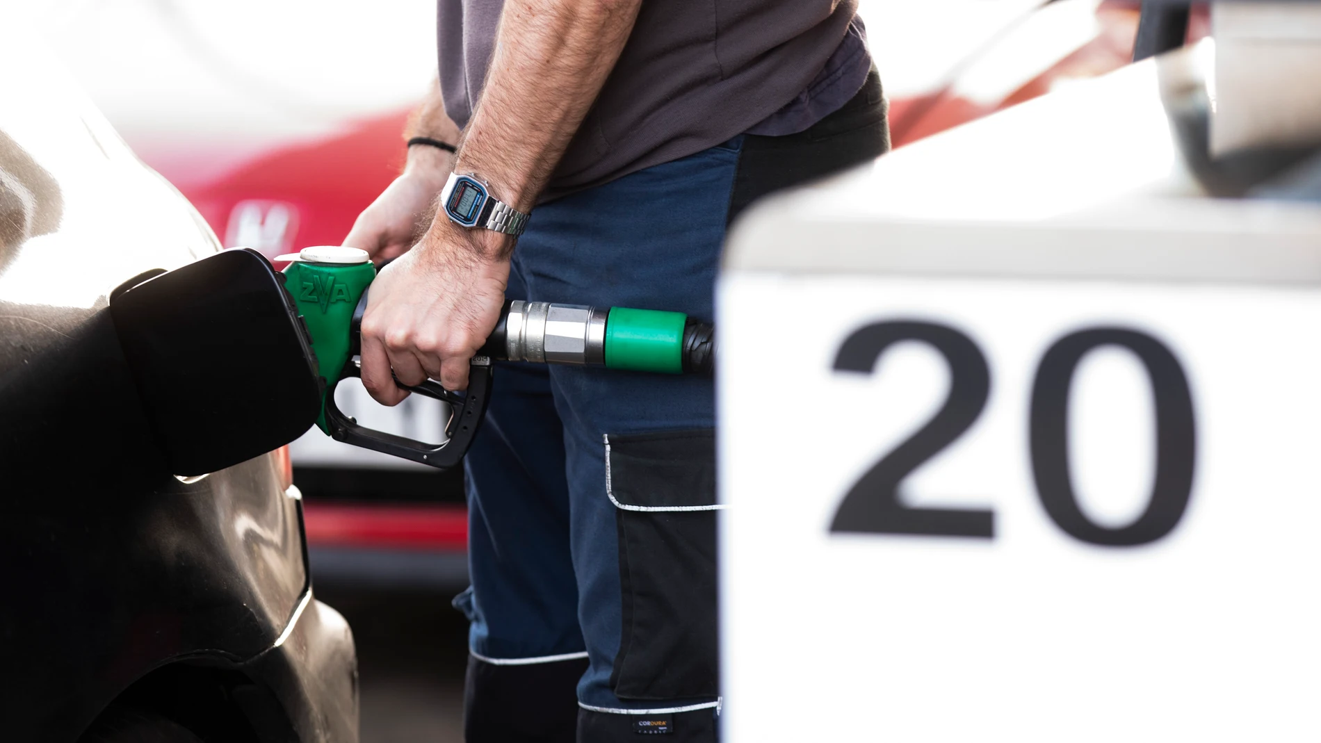 Hombre echando gasolina en una gasolinera