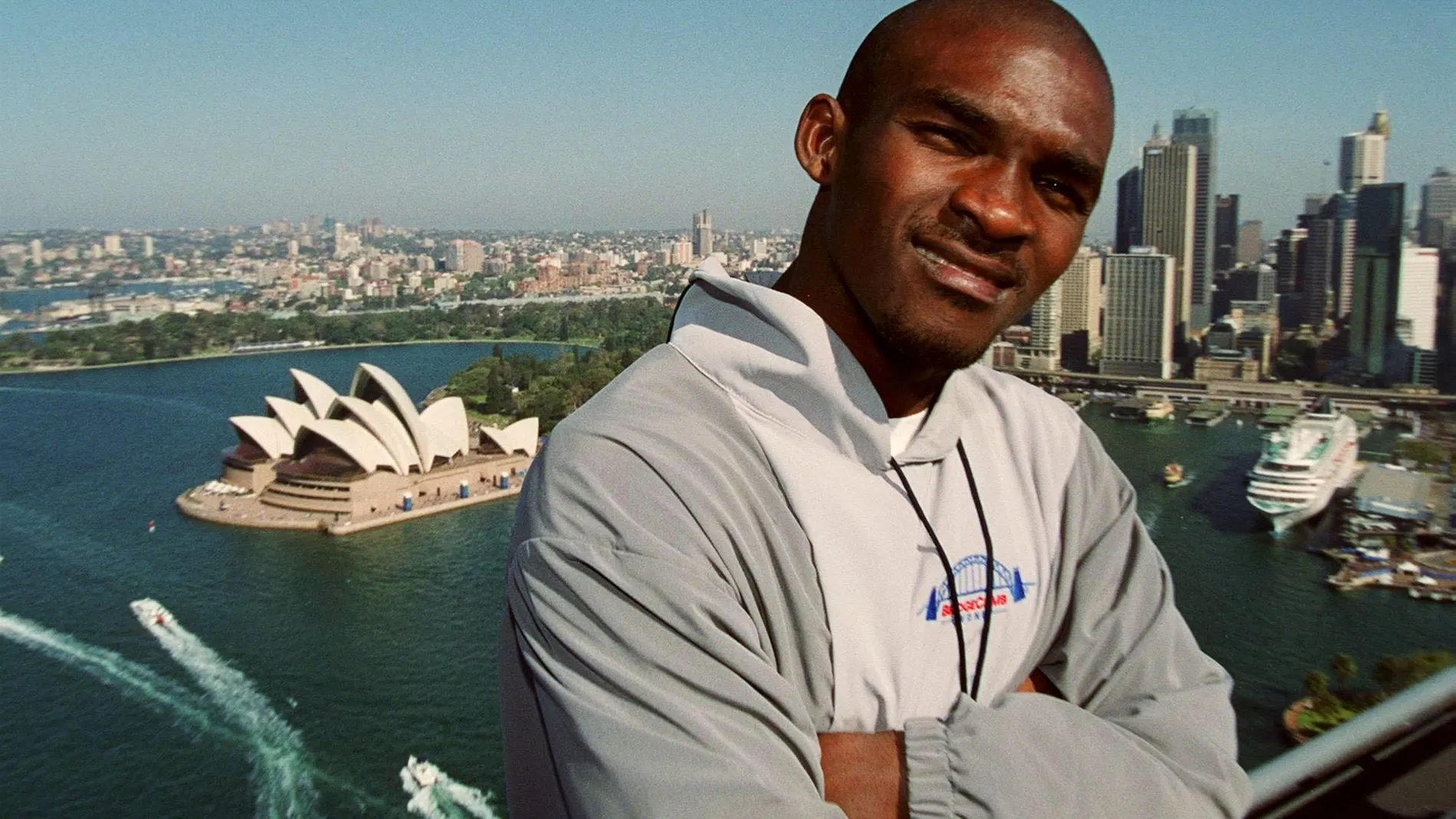 Eric Moussambani, con la bahía de Sídney al fondo