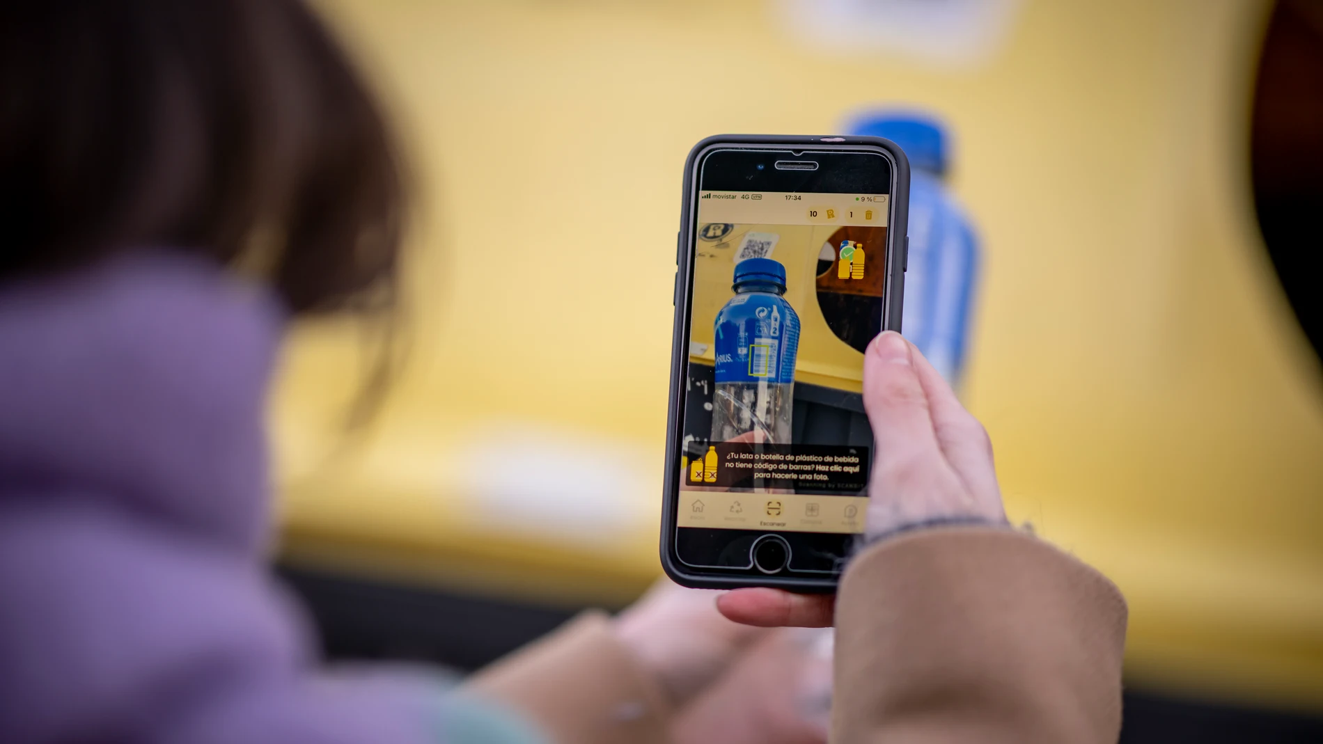 Una mujer consulta la app RECICLOS en su móvil