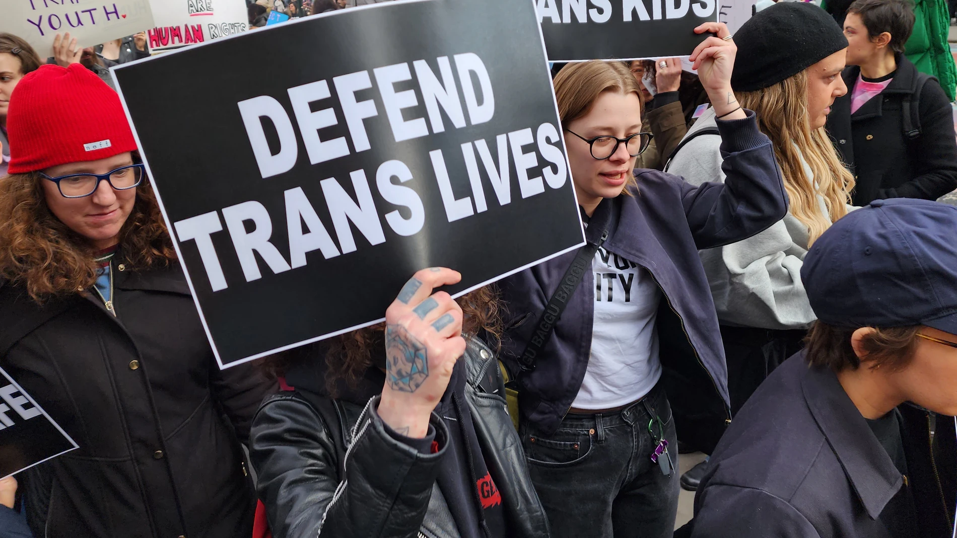 USA8168. NUEVA YORK (NY, EEUU), 23/10/2024.- Fotografía de archivo del 31 de marzo de 2023 donde aparecen unos jóvenes mientras portan pancartas que piden defensa a vidas y niños trans, durante una manifestación en Nueva York (EE.UU.). Las afirmaciones del candidato republicano Donald Trump sobre supuestas escuelas de EE.UU. donde se adoctrina a niños para que se sometan a tratamientos de transición de género se han instalado en la campaña electoral, transformando un asunto residual en factor...