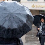 Viandantes se protegen con paraguas durante una mañana lluviosa en Teruel, este domingo. 