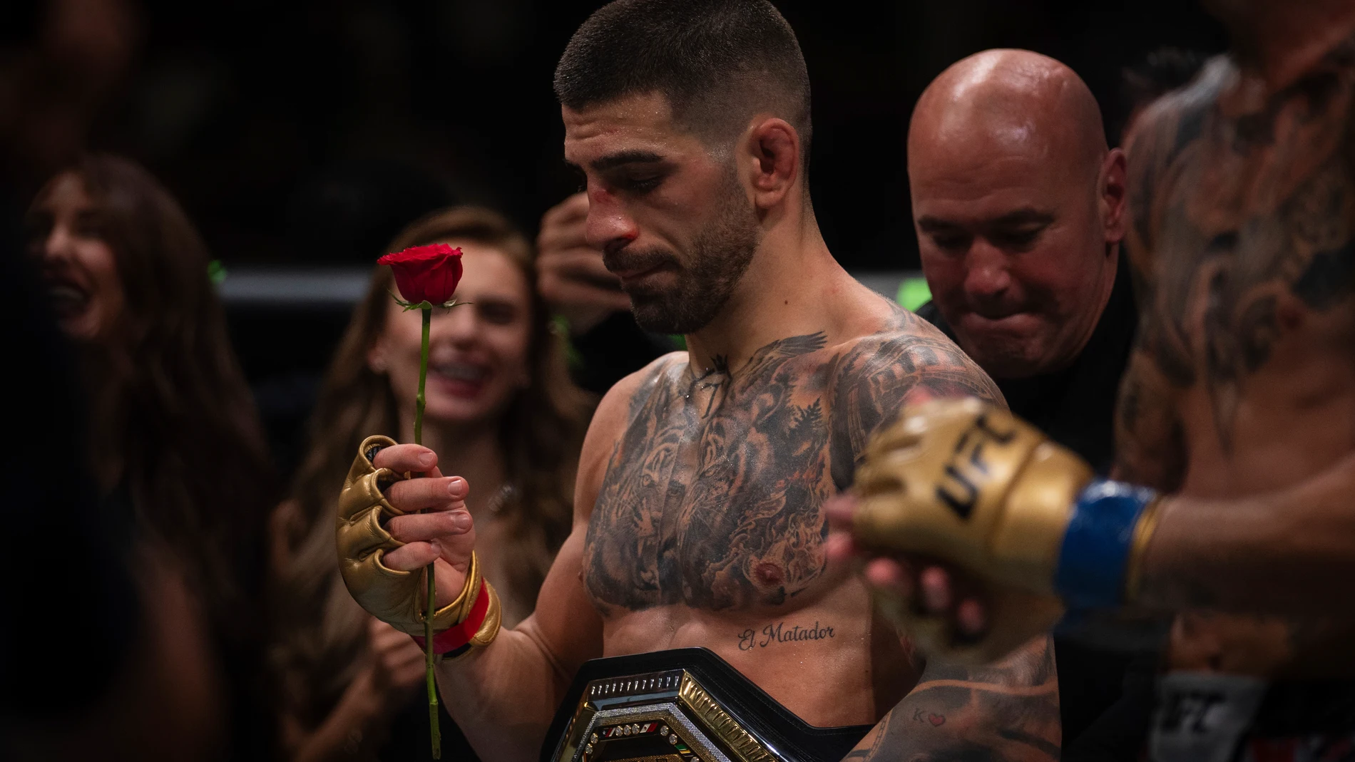 UFC featherweight champion Ilia Topuria, holds a rose presented to him by his wife after winning the featherweight title mixed martial arts bout against No. 2 ranked Max Holloway at UFC Fight Night on Saturday, Oct. 26, 2024, in Abu Dhabi, United Arab Emirates. Topuria won the fight. (AP Photo/Altaf Qadri)