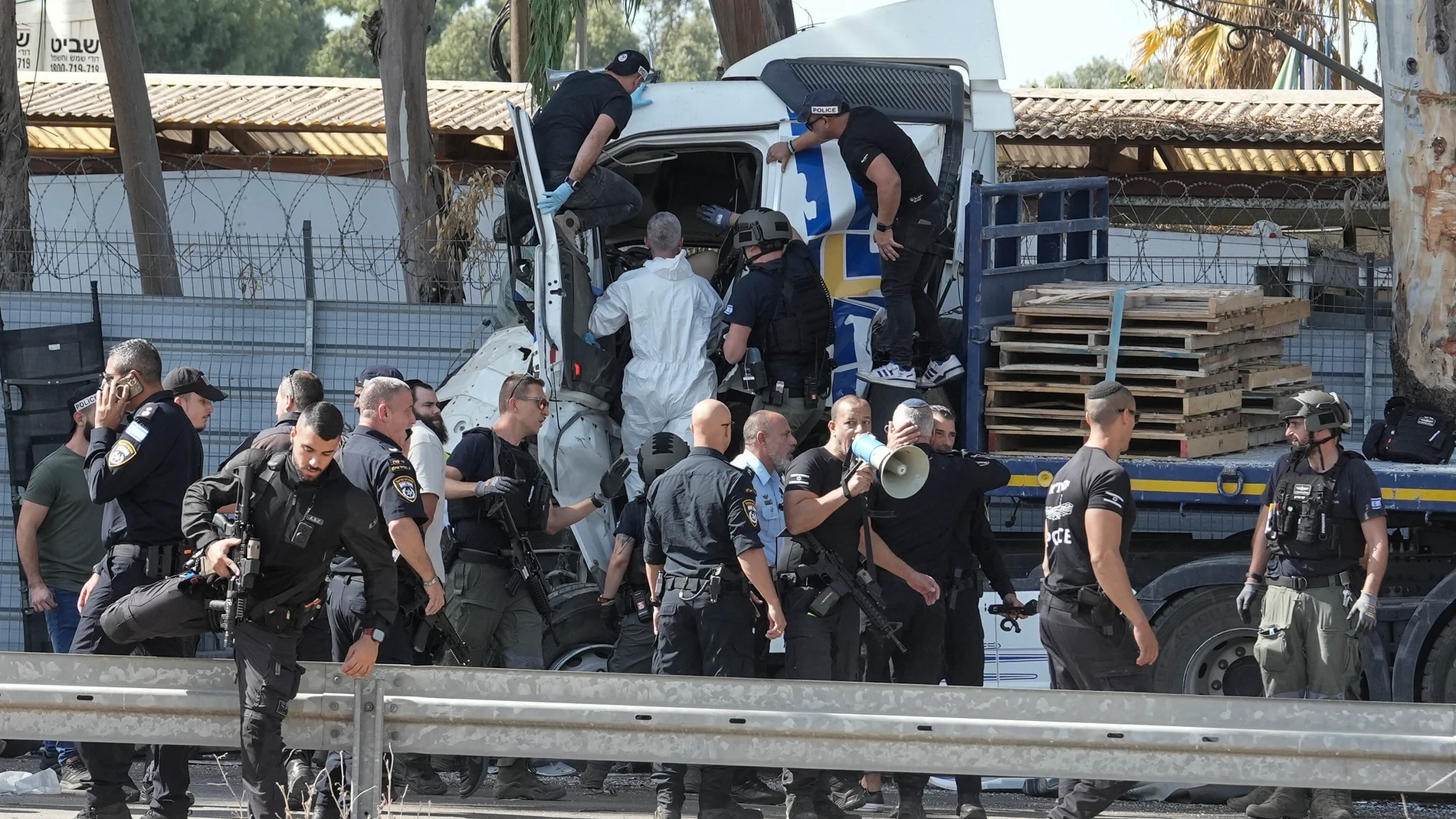 Israeli police climb on a truck that rammed into a bus stop near the headquarters of Israel's Mossad spy agency, wounding dozens of people, according to Israel's Magen David Adom rescue service in Tel Aviv, Israel, Sunday, Oct. 27, 2024. (AP Photo/Oded Balilty)