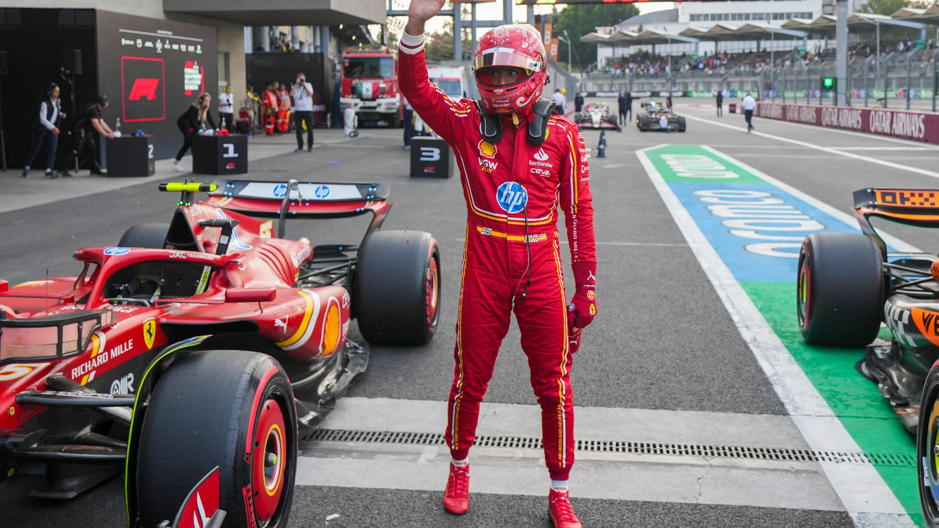 Ferrari driver Carlos Sainz, of Spain, waves after winning the pole position for the Formula One Mexico Grand Prix auto race at the Hermanos Rodriguez racetrack in Mexico City, Saturday, Oct. 26, 2024. (AP Photo/Fernando Llano)