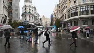 Viandantes se protegen de la lluvia con paraguas por el centro de Madrid Viandantes se protegen de la lluvia con paraguas por el centro de Madrid