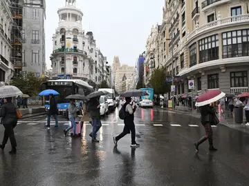 Viandantes se protegen de la lluvia con paraguas por el centro de Madrid Viandantes se protegen de la lluvia con paraguas por el centro de Madrid