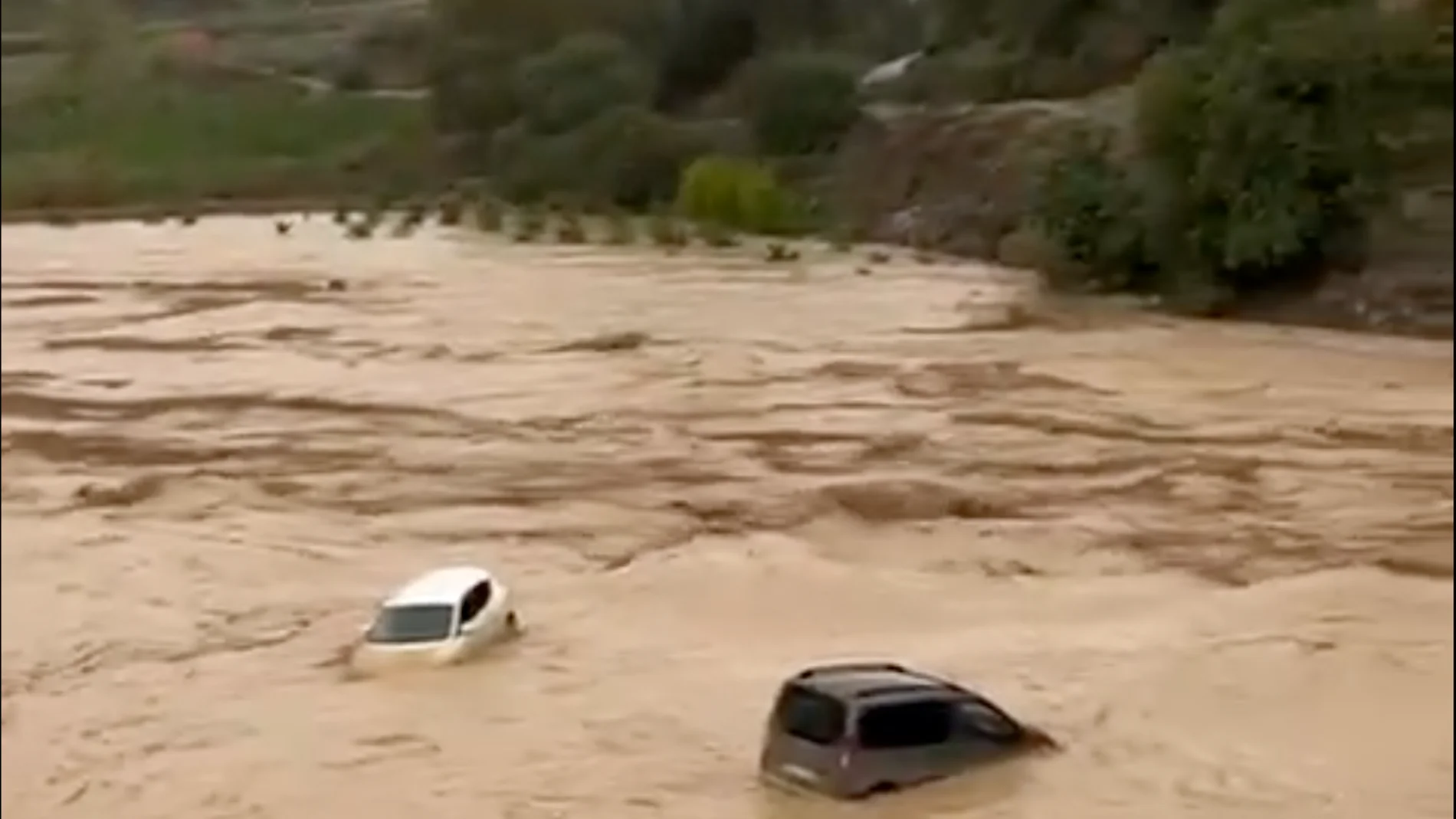 Vehículos siendo trasladados por el agua en el río Guadalhocer, en Álora (Málaga)