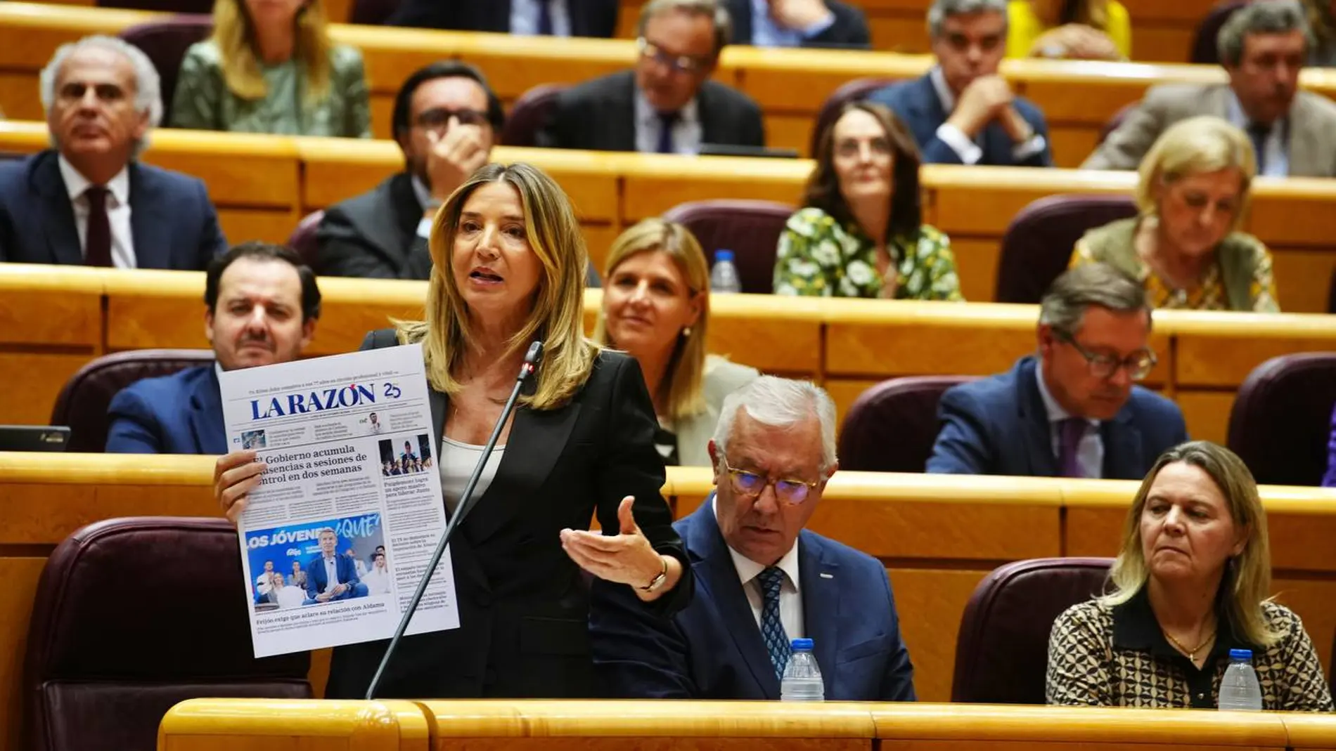 La portavoz del PP, Alicia García, durante la sesión de control al Gobierno con la portada de LA RAZÓN de este lunes.