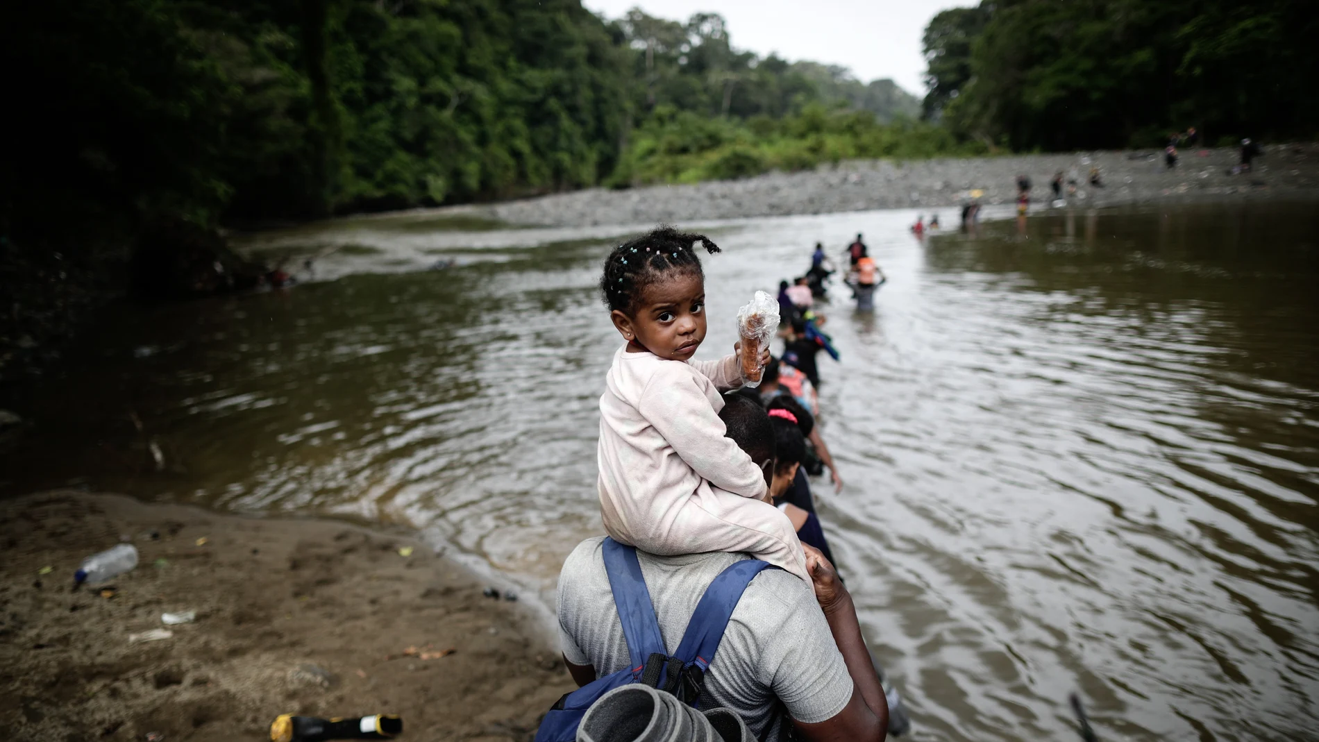 DARIÉN (PANAMÁ), 20/12/2023.- Migrantes cruzan el río Turquesa, el 14 de septiembre de 2023 ,en Darién (Panamá). Horrible, horrible, repiten muchos migrantes. El paso por la selva del Darién, la frontera natural entre Panamá y Colombia, no es como imaginaron. Guiados por videos que inundan las redes sociales y el relato de conocidos, la desinformación y el engaño acentúan la crisis migratoria. EFE/ Bienvenido Velasco
