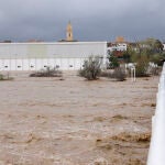Dos personas contemplan el gran caudal del río Magre a su paso por Alfarp (Valencia) debido a las lluvias torrenciales que afectan a la Comunitat Valenciana, y especialmente a la provincia de Valencia, en la que se ha establecido el aviso rojo