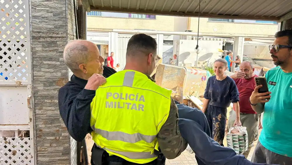 Un efectivo de la Policía Militar traslada a un vecino