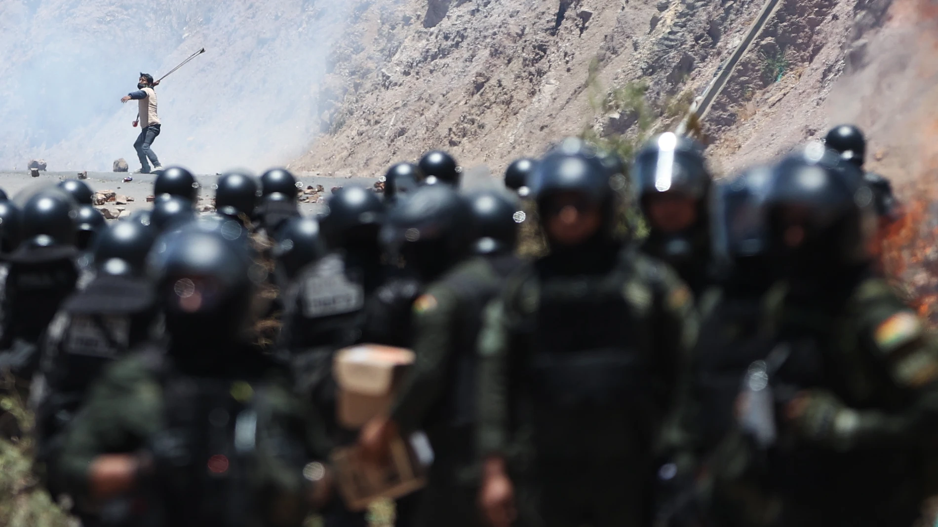 AME3895. PAROTANI (BOLIVIA), 01/11/2024.- Un hombre se enfrenta con miembros de la Policía Militar Boliviana durante un bloqueo por simpatizantes del expresidente de Bolivia, Evo Morales (2006-2019) este viernes, en Parotani (Bolivia). Un gran contingente de policías y militares bolivianos desbloquean las carreteras tomadas por los seguidores de Morales desde hace 19 días, medida que ejercen en defensa de su líder ante una posible orden de captura en su contra por un caso de trata de personas...